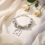 Silver bracelet with charm on a beige fabric background with roses