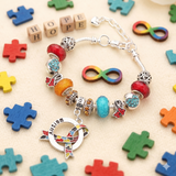 Autism awareness luxury charm bracelet flat lay showing all 12 charms and central hanging charm