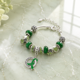 Silver muscular dystrophy awareness charm bracelet on glossy light green marble background